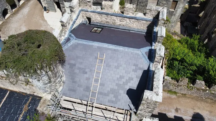 Completed slate roof set against a rural landscape